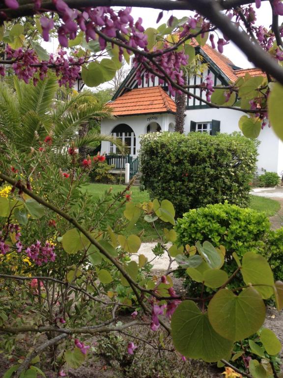 une maison blanche avec un toit rouge et quelques fleurs dans l'établissement villa manhé, à La Teste-de-Buch