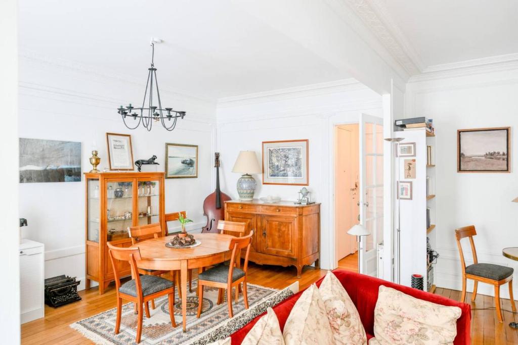 un salon avec un canapé rouge et une table dans l'établissement Bel appartement pour 2 personnes by Weekome, à Paris