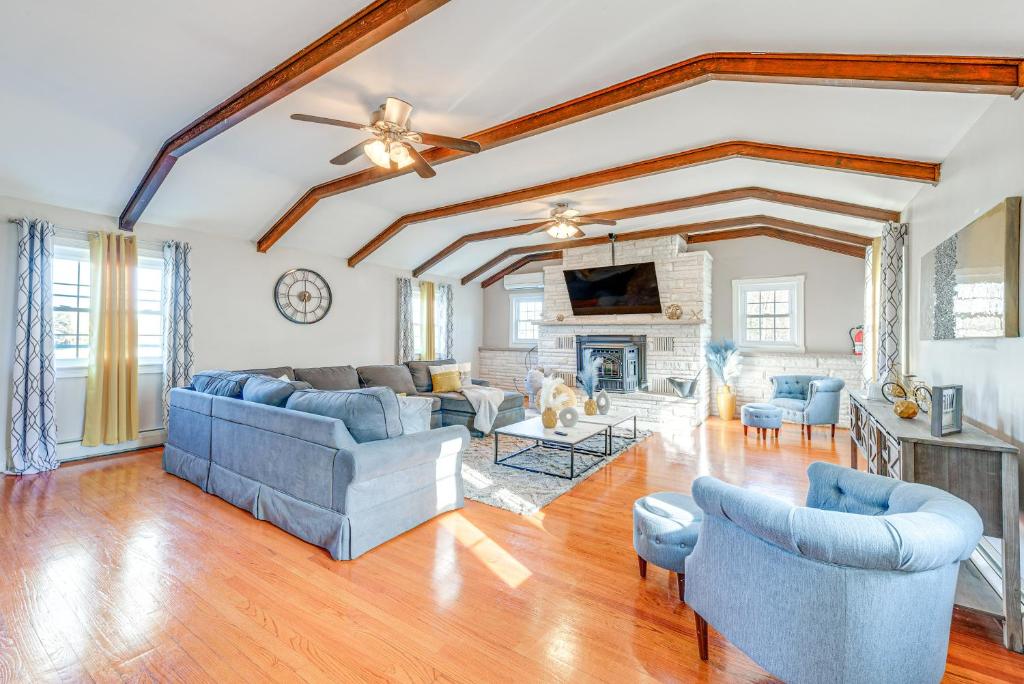 a living room with blue couches and a fireplace at Poconos Group Getaway w/ Game Room + Fire Pit! in Daleville