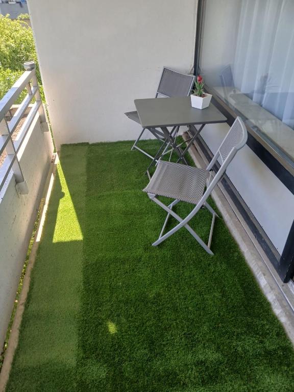 Hotel Sweet-Home, a table and chairs on a balcony with green grass at Sweet-Home in Hannover