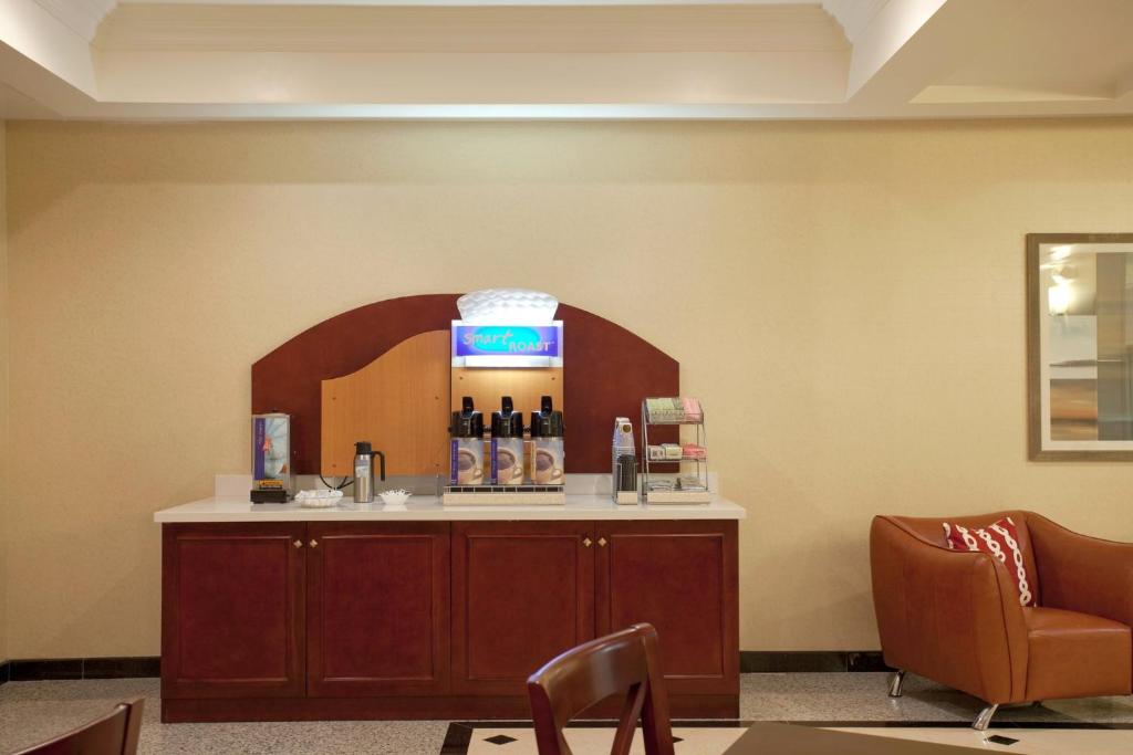 a waiting room with a counter with bottles of wine at Holiday Inn Express Hotel & Suites Los Angeles Airport Hawthorne by IHG in Hawthorne
