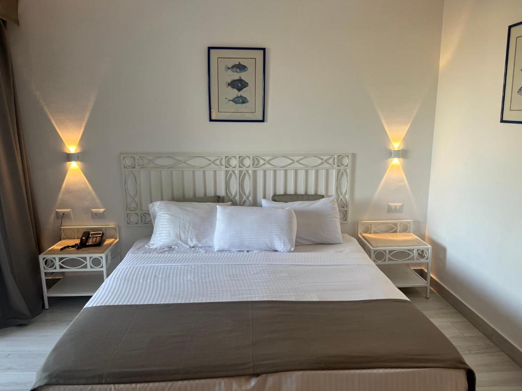 a bedroom with a large bed with two night stands at Domina Coral Bay Aquamarine in Sharm El Sheikh