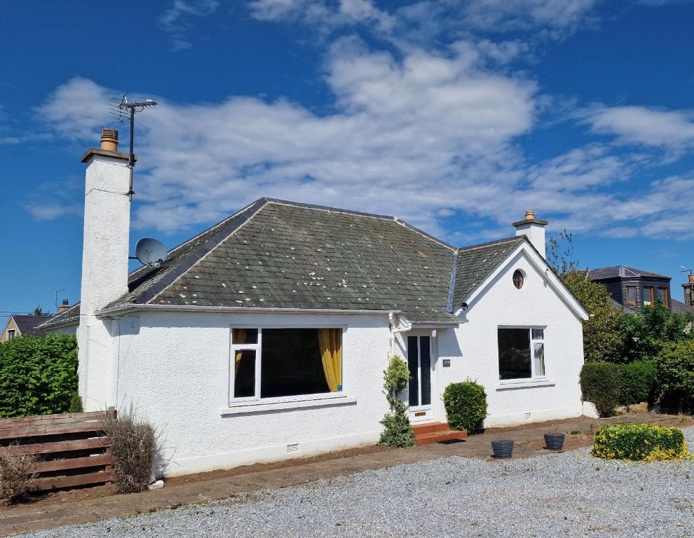 a white house with a chimney on top at Catalina - Modern 2 bedroom bungalow in Elgin
