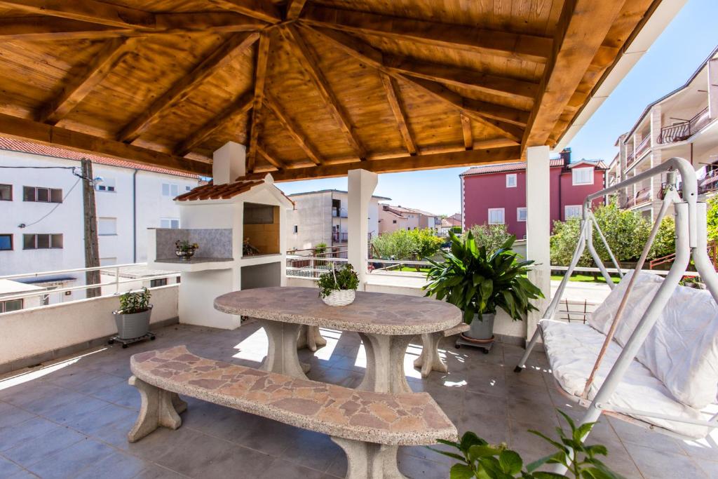 een patio met een tafel en banken op een dak bij Apartments Ivica in Split