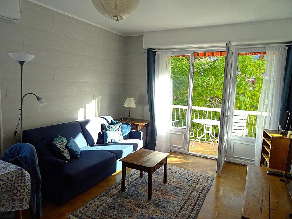 un salon avec un canapé bleu et une table dans l'établissement Le Verlaine, à Annecy