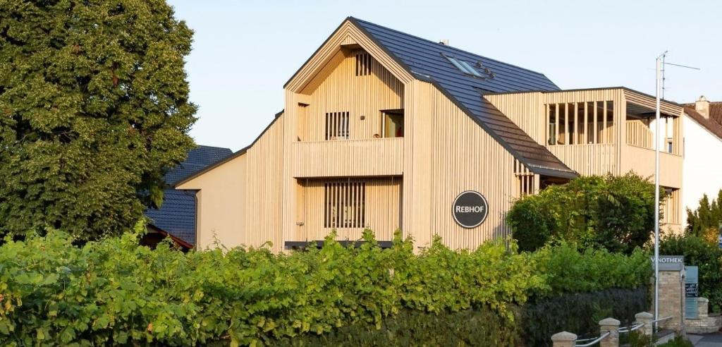 a large wooden building with a black roof at Ferienhaus Rebhof in Nonnenhorn