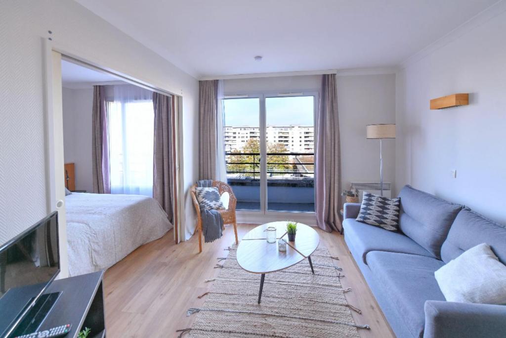 un salon avec un canapé et une table dans l'établissement Bright with balcony at Buttes Chaumont, à Paris