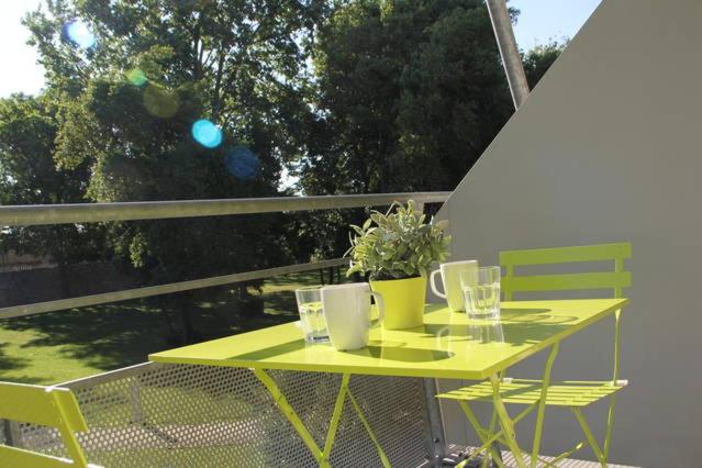 une table et des chaises jaunes sur un balcon dans l'établissement Les Cyclades, à Arles