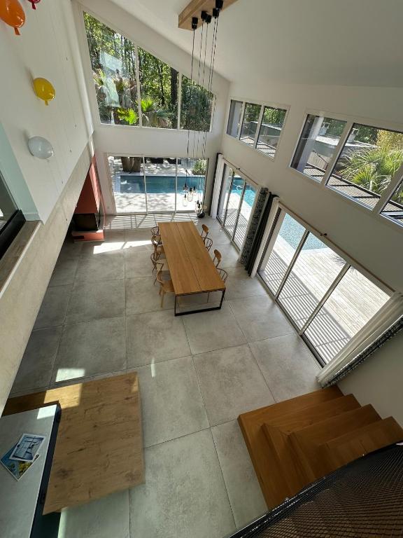 - une vue de tête sur un salon avec une table et des bancs dans l'établissement Casa Stella, à Lège-Cap-Ferret