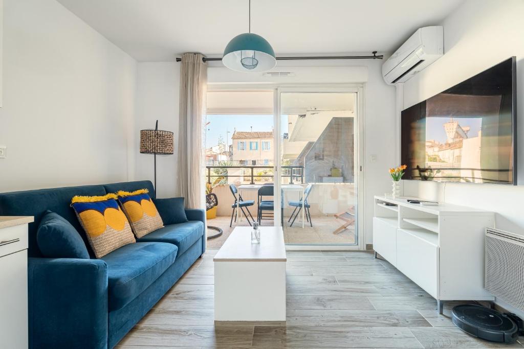 un salon avec un canapé bleu et une table dans l'établissement Liberté, à La Ciotat