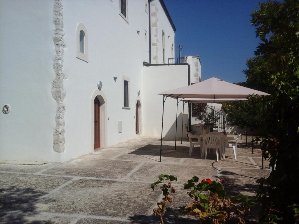 a patio with an umbrella and a table and chairs at Agriturismo della Torre in Peschici