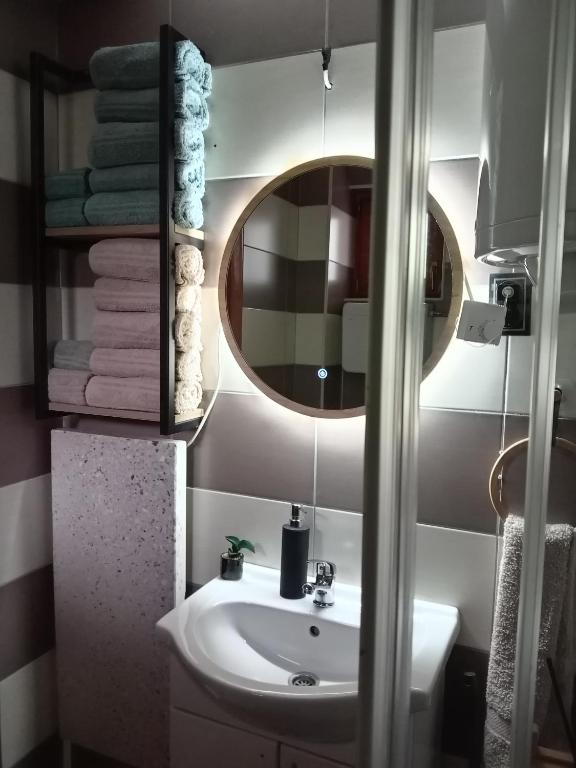 a bathroom with a sink and a mirror and towels at Simic Apartmani Tara in Kaludjerske Bare