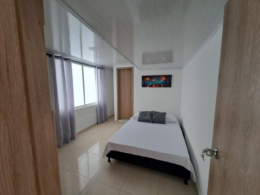 a bedroom with a bed and a large window at Hotel Villa Coral in Pereira