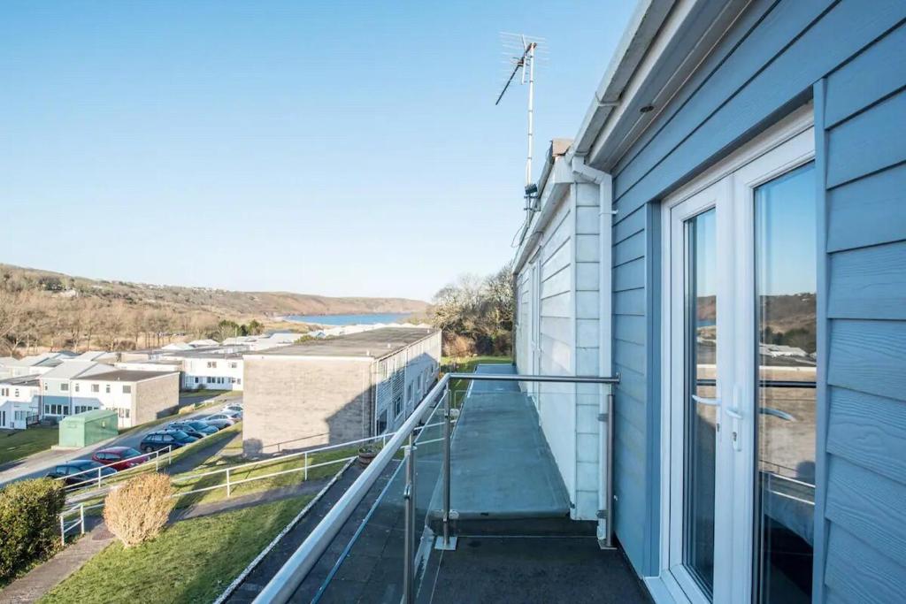 un balcón con vista a un edificio en Charming Beach Chalet with Balcony & Sea Views, en Pembrokeshire