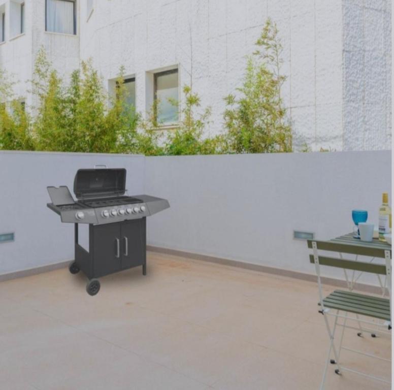 un barbecue dans une cour arrière avec un mur blanc dans l'établissement Playa Son Moll, à Cala Ratjada
