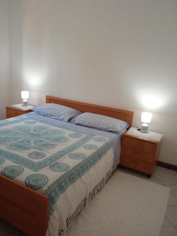 a bedroom with a bed with two night stands and two lamps at Lungomare 2 in Porto Alabe