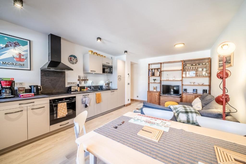 une cuisine et un salon avec un canapé et une table dans l'établissement SIKA C208 Magnifique T3 au centre du village, à Morzine