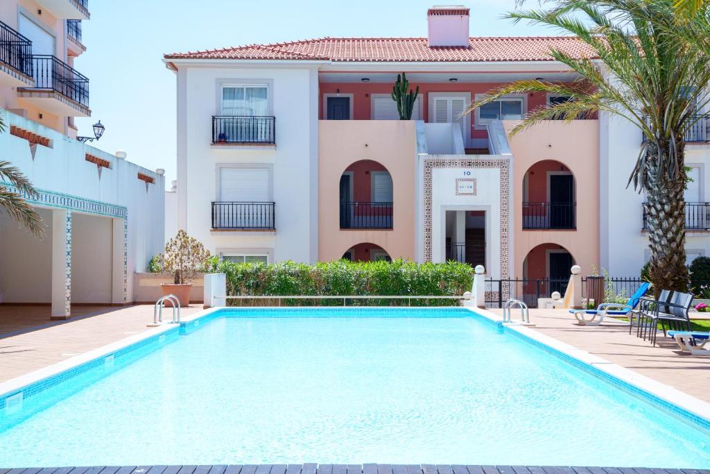 a swimming pool in front of a villa at Esplendor beiramar refúgio na Praia del Rey B9 in Amoreira