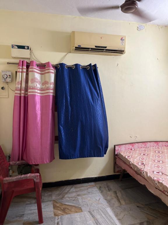 a room with blue and pink curtains and a bed at Srinivasa Homestay in Tiruvannāmalai