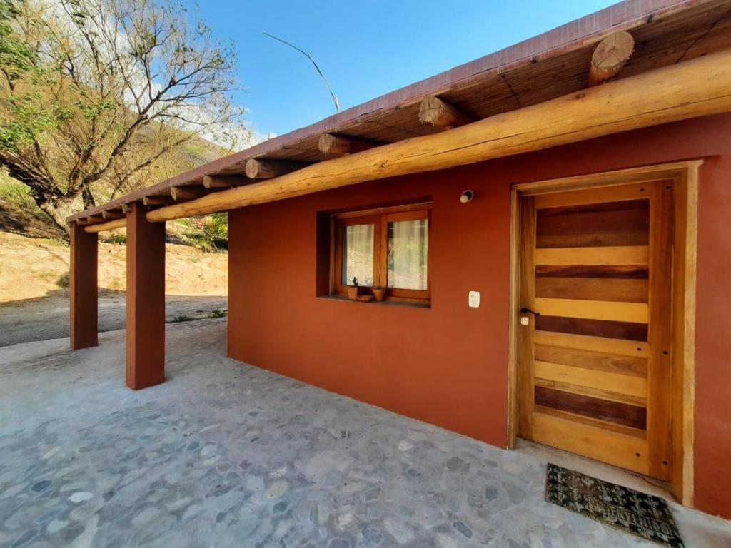 a house with a wooden door and a porch at El Hornero in Tilcara