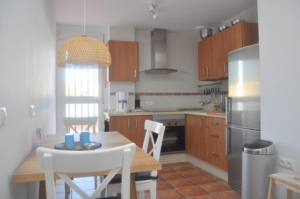 a kitchen with a table and chairs and a refrigerator at Casa Sandra in Arcos de la Frontera