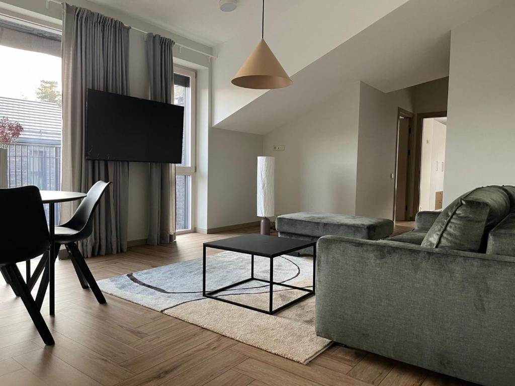 ein Wohnzimmer mit Sofa und Tisch in der Unterkunft MiMi Palanga - Self Check-in in Palanga