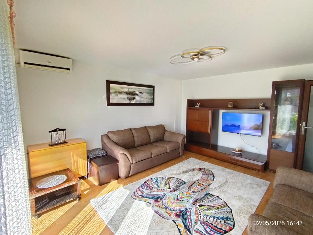 a living room with a couch and a flat screen tv at ARKA Apartment in Craiova