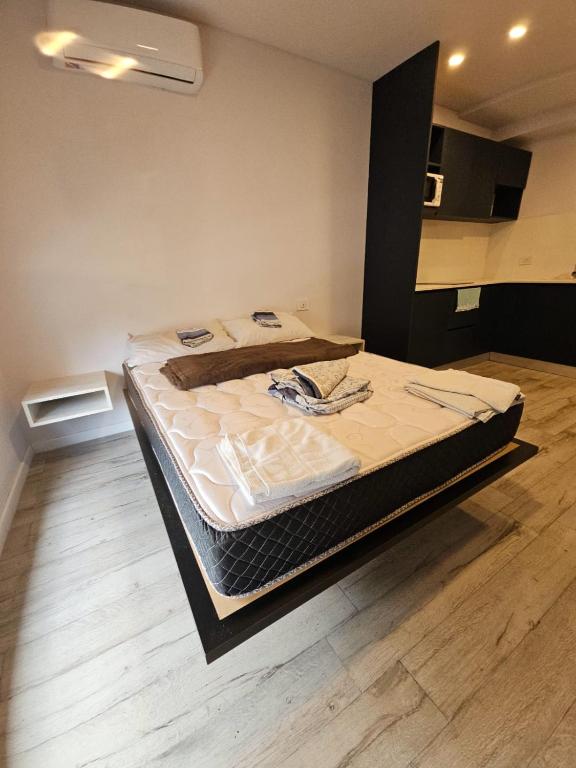 a large bed in a room with a wooden floor at Alquiler Temporario Rosario 23 in Rosario