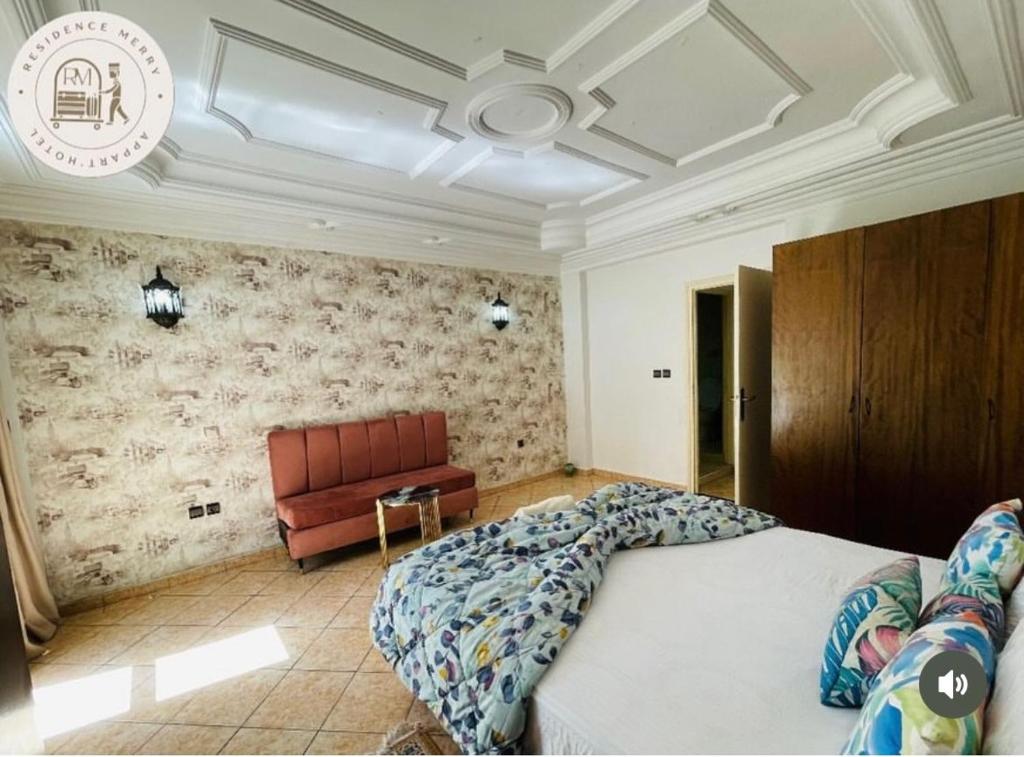a bedroom with a bed and a red couch at Merry Studio Hotel in Agadir