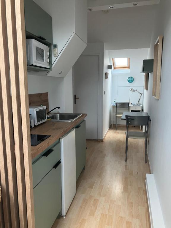 a small kitchen with a sink and a table at Studio centre-ville climatisé avec parking gratuit in Clermont-Ferrand