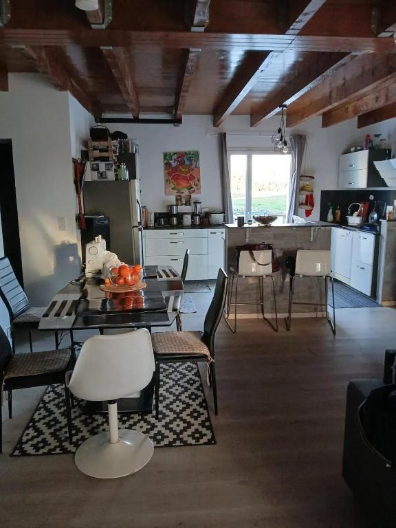 une cuisine et un salon avec une table et des chaises dans l'établissement Maison confortable à Comps-la-Grand-Ville avec jardin, à Comps-la-Grand-Ville