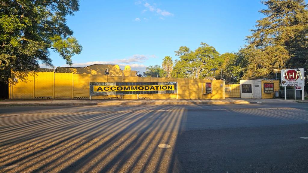 Una pared amarilla con un cartel que dice combustión del acelerador en AHA Accommodation, en Piet Retief