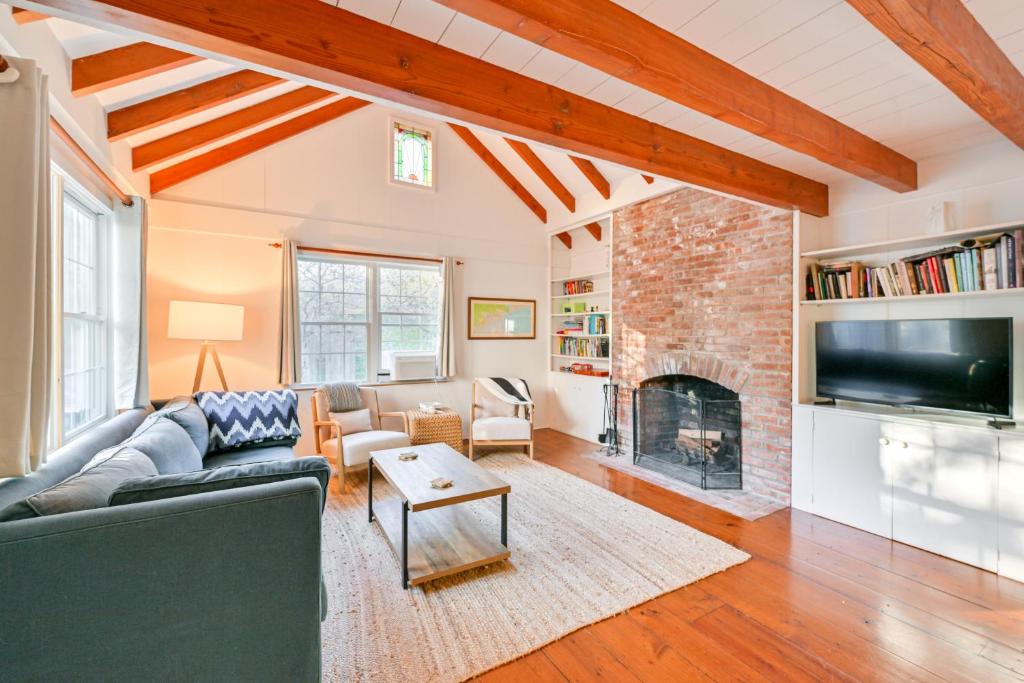 a living room with a couch and a fireplace at Walk to Amagansett Beach Cottage with Deck! in Amagansett