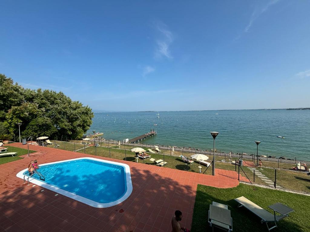 a swimming pool with a view of the ocean at Gardazzuro Appartment Deluxe in Padenghe sul Garda