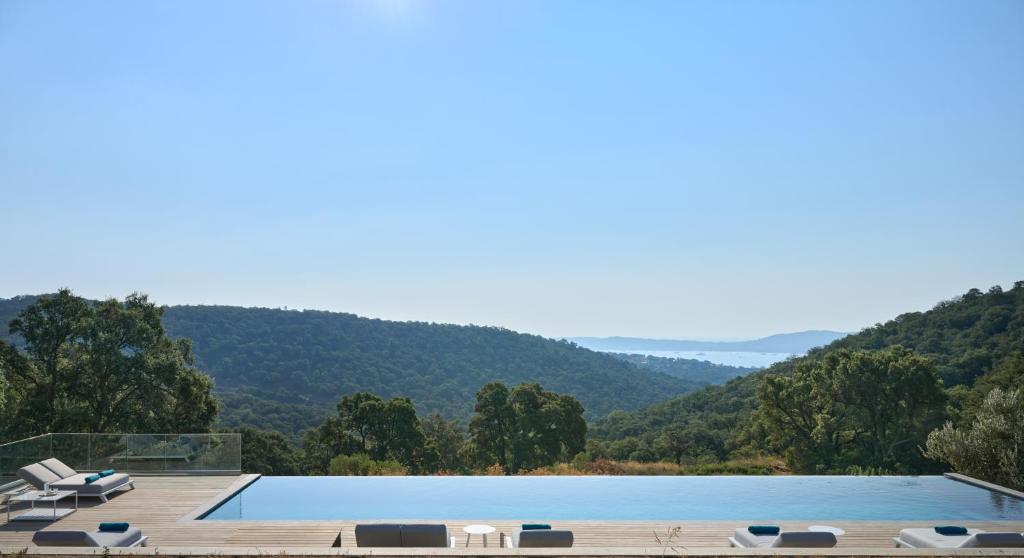 une piscine avec des montagnes en arrière-plan dans l'établissement Domaine du verneton, à Les Brugassières