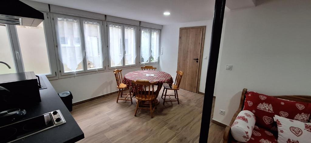 une cuisine avec une table et des chaises dans une pièce dans l'établissement le nid de la cigogne, à Sainte-Marie-aux-Mines