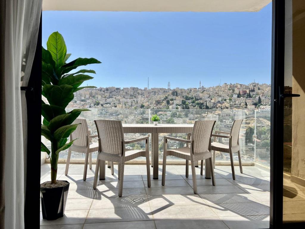 a table and chairs on a balcony with a view at Brand new, Modern, Breathtaking view, just for you in Amman