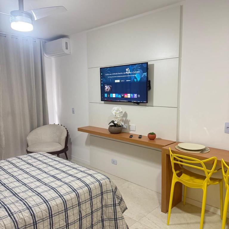 a bedroom with a bed and a tv on a wall at 81NV Studio Liberdade SP 300 Metros Estação Japão até 03 pessoas in São Paulo
