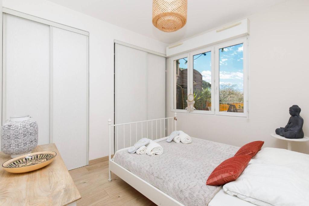 une chambre blanche avec un lit et une fenêtre dans l'établissement Juan les pins confort et commodites, à Antibes