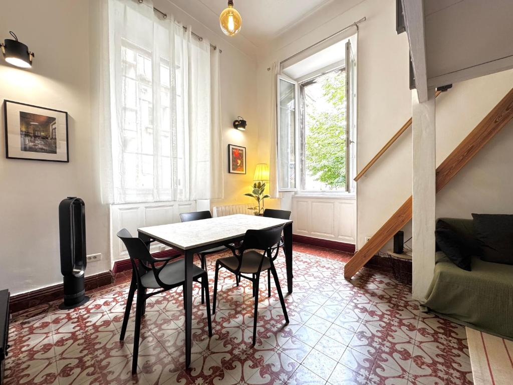 une salle à manger avec une table et des chaises dans une pièce dans l'établissement La Loge Urbaine - Cœur de Ville, à Avignon