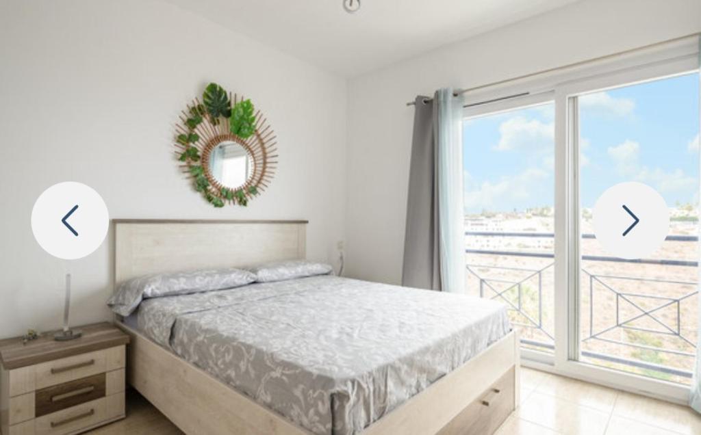 een slaapkamer met een bed en een groot raam bij Residence Vista Golf in Mogán