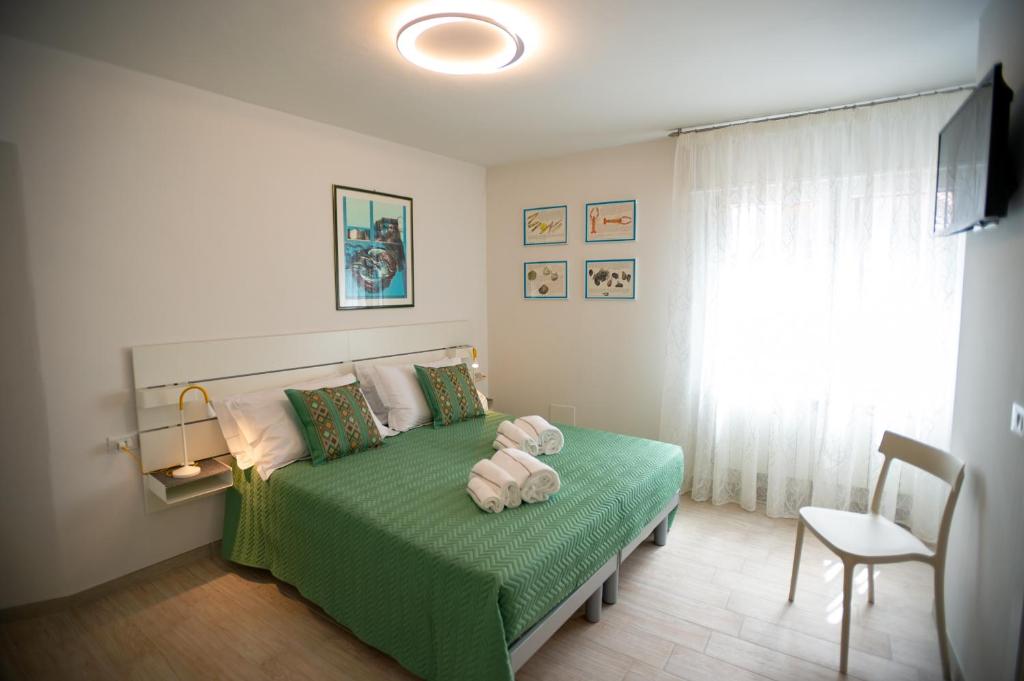 CASA LILLY camere matrimoniali con bagno privato في كيودجا: غرفة نوم بسرير اخضر ونافذة