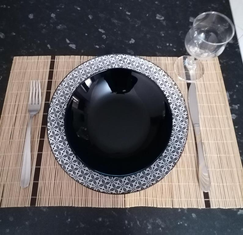 a plate on a table with a fork and a glass at ANNA'S HOME Ιωάννινα in Ioannina
