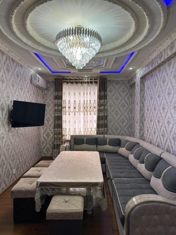 Una sala de estar con un sofá y una lámpara de araña. en Gurman Guest house by SamApart, en Samarkand