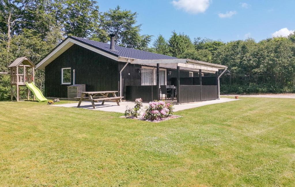 a small house with a playground and a slide at 3 Bedroom Beautiful Home In Toftlund in Toftlund