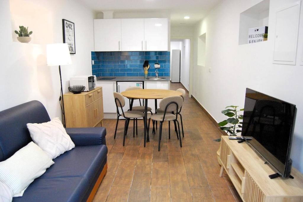 un soggiorno con un divano, un tavolo e una cucina di Blue House in the Old Town Setúbal a Setúbal