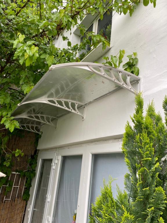 awning over a window on a house with trees at Otthon in Budaörs