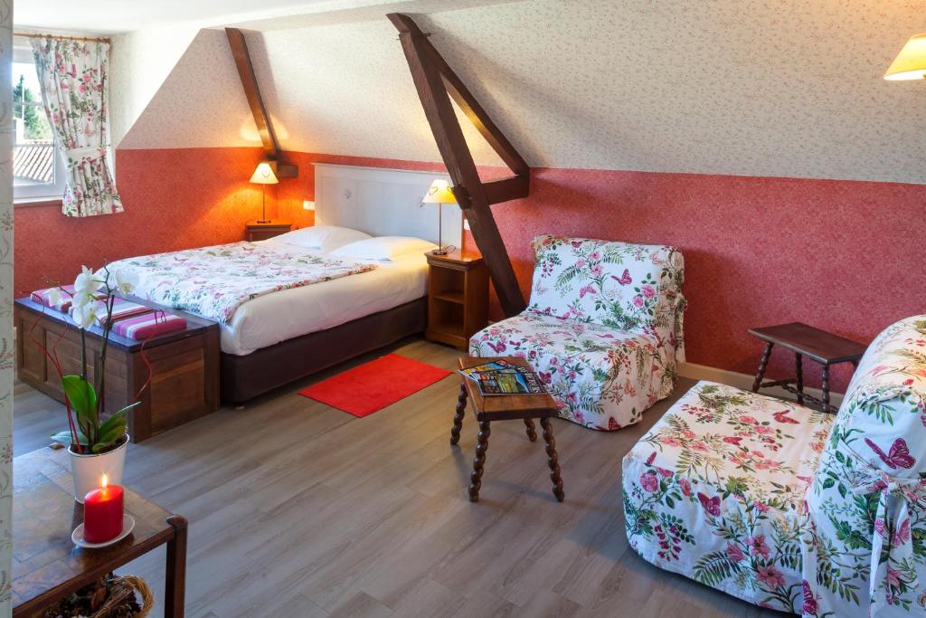 a hotel room with a bed and a chair at Logis Auberge le centre poitou in Coulombiers