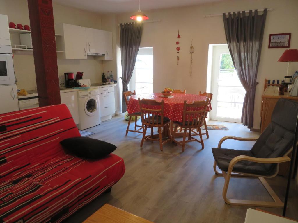 - un salon avec un canapé rouge, une table et des chaises dans l'établissement Appart 6 personnes, 2ch, parking, centre-ville, à Cauterets