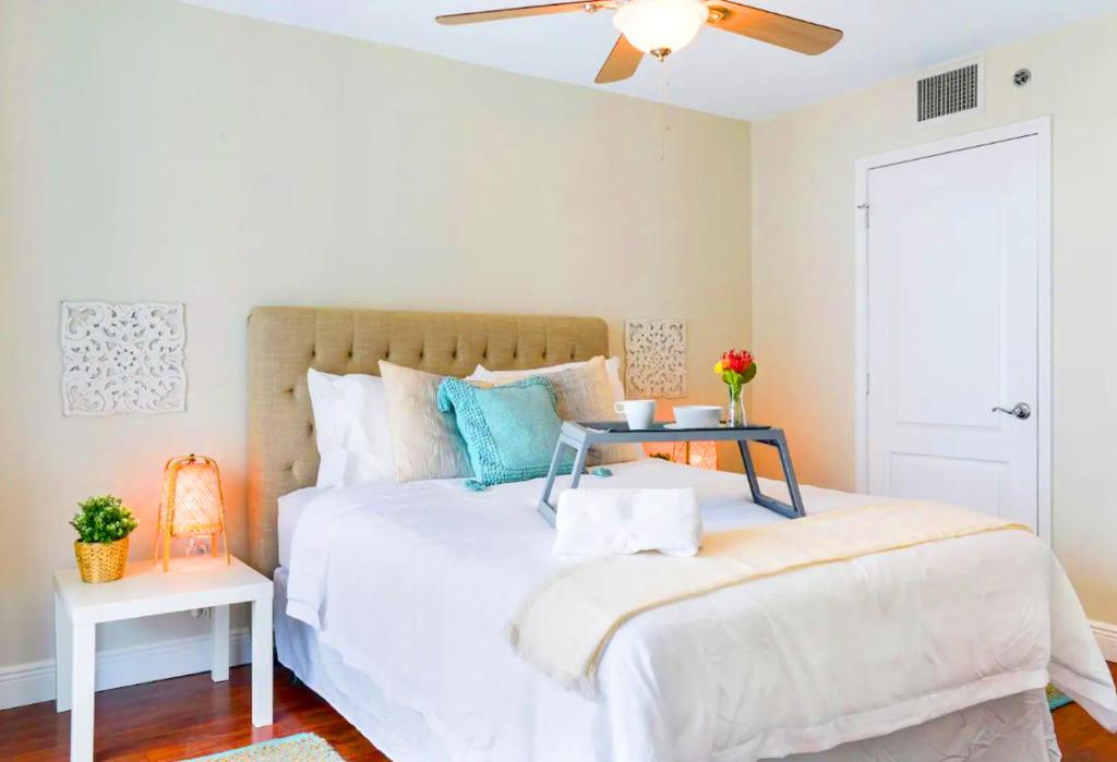 a bedroom with a white bed with a table on it at LUXURY 2 Bedroom Apartment At BRICKELL with pool in Miami